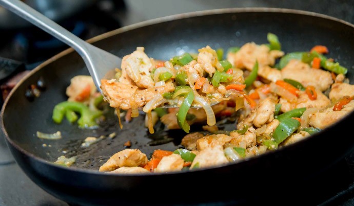 AfterFair Aus einer großen Pfanne wird Essen geschöpft.