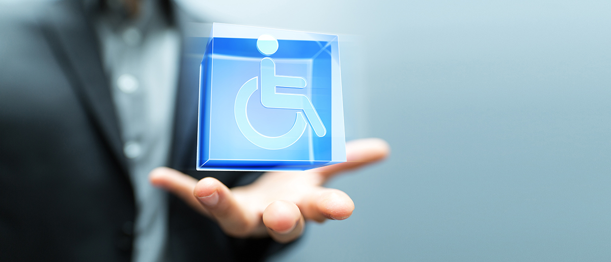 Barrierefreie Messe Eine Hand symbolisch einen Würfel, auf dem ein Rollstuhl-Icon abgebildet ist